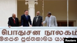 Britain's PM David Cameron (2nd L), Chief Minister of Northern province, C. V. Vigneswaran (2nd R) and Sri Lankan Tamil National Alliance (TNA) party leader R. Sampanthan (L) look out from the public library in Jaffna, north of Colombo, Nov. 15, 2013. 