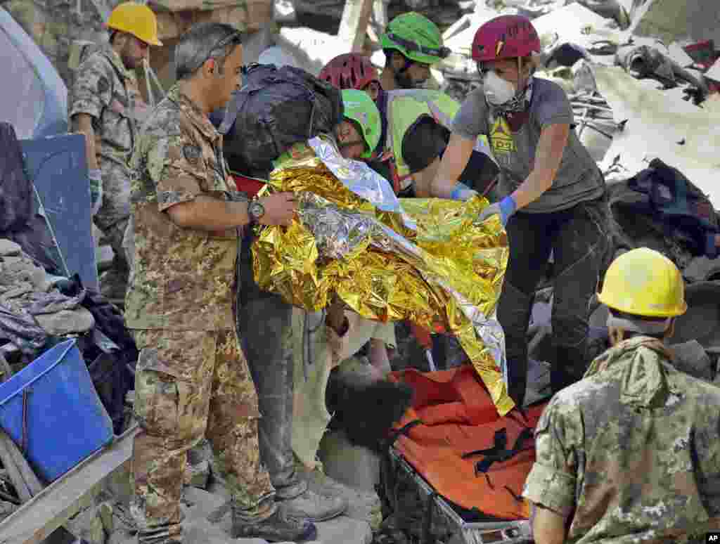 The body of a victim is pulled out of the rubble following an earthquake in Amatrice, Aug. 24, 2016.