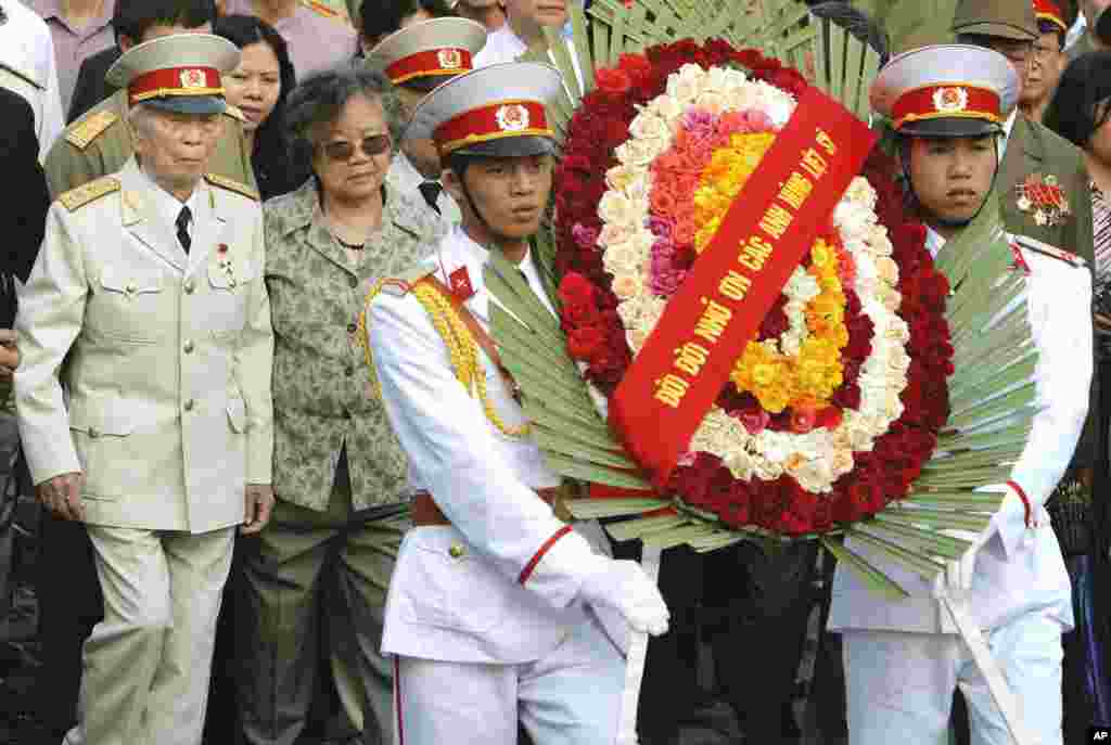 Tướng Võ Nguyên Giáp đi sau đội quân danh dự trong buổi lễ đặt vòng hoa kỷ niệm 50 năm trận Điện Biên Phủ tại nghĩa trang ở Điện Biên Phủ, ngày 18/4/2004. (AP Photo/Richard Vogel)