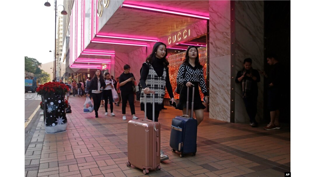 FILE - Chinese tourists walk on Canton Road, the one-stop-shop street of high-end brands in Hong Kong, Nov. 29, 2018.
