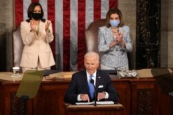 Wapres Kamala Harris dan Ketua DPR Nancy Pelosi bertepuk tangan di tengah pidato Presiden Joe Biden, Rabu malam (28/4).