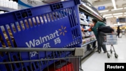 FILE - A shopping cart full of products is seen as a customer shops at a Wal-Mart store in Beijing.
