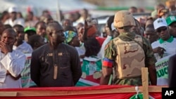 A Nigerian soldier (r) provides security as Nigerian President Goodluck Jonathan, not pictured, speaks to supporters in Yola, Nigeria, Jan. 29, 2015.