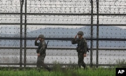 한국 정부가 북한에 군사분계선 일대의 적대행위 중지를 위한 군사당국 회담을 제안한 17일, 경기도 파주에서 철책을 순찰하는 군인들이 거수경례를 하고 있다.