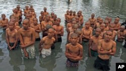 Youths stand in the pond located at a police school, after having their heads shaved by the police, in Aceh Besar of the Indonesia's Aceh province, December 13, 2011.