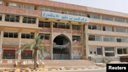 A damaged building is pictured after a shelling in Qaser Bin Ghashir, near the Tripoli International Airport, July 26, 2014. 