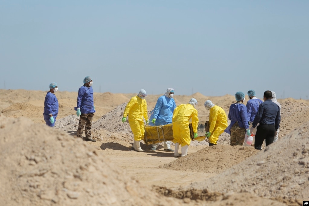 Los trabajadores del Ministerio de Salud iraquí llevan un ataúd a un nuevo cementerio para las personas que murieron de COVID-19, en las afueras de la ciudad de Najaf, Iraq.&nbsp;