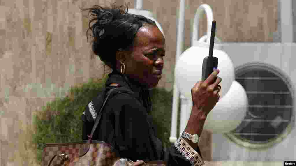 A woman tries to get reception on her mobile phone in Maiduguri, after the military declared a 24-hour curfew over large parts of the city in Borno State May 19, 2013.