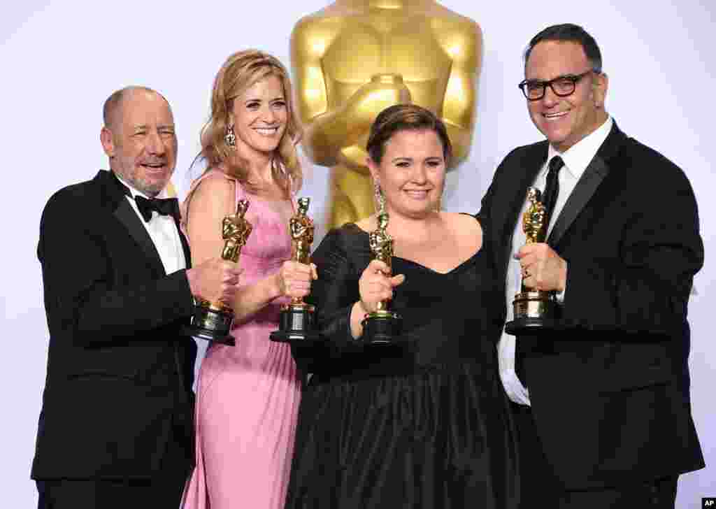 Steve Golin, from left, Blye Pagon Faust, Nicole Rocklin and Michael Sugar, winners of the award for best picture for “Spotlight” pose in the press room at the Oscars on Feb. 28, 2016, at the Dolby Theatre in Los Angeles.