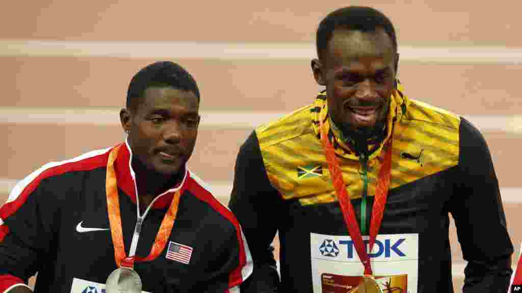 Usain Bolt, le médaillé d'or au 100 m aux championnats d’athlétisme de Pékin 2015, pose avec son rival de tout le temps, l’Américain Justin Gatlin, arrivé en deuxième position avec une médaille d’argent, à Pékin, Chine, 24 août 2015.