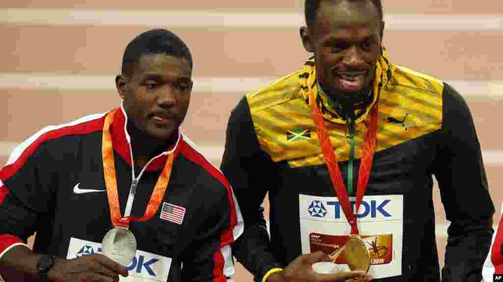 Médaillé d&#39;or, Usain Bolt de la Jamaïque, à droite, se tient sur le podium avec la médaillée d&#39;argent Justin Gatlin des États-Unis au cours de la cérémonie de remise des médailles de la finale du 100m aux Championnats du monde d&#39;athlétisme au stade Nid d&#39;oiseau à Pékin, 24 août 2015.&nbsp;
