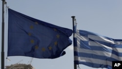 A European Union (L) and Greek flag wave in front of the Parthenon temple in Athens (File Photo)