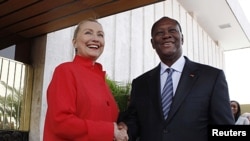 U.S. Secretary of State Hillary Clinton and Ivory Coast President Alassane Dramane Ouattara shake hands after holding a joint news conference at the Presidency in Abidjan, January 17, 2012.