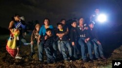 Inmigrantes de Honduras y El Salvador que cruzó la frontera entre México y EE.UU. son detenidos en Granjeno, Texas, el 25 de junio de 2014.