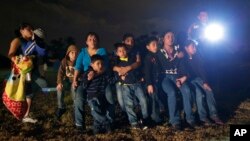 FILE - A group of immigrants from Honduras and El Salvador who crossed the Mexico-U.S. border illegally are seen stopped in Granjeno, Texas, June 25, 2014.