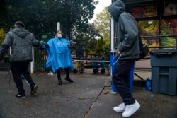 Volunteer Dawn Cherry, center, hands out boxed meals prepared at the South Bronx restaurant La Morada, Wednesday Oct. 28, 2020, in New York.