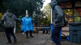Volunteer Dawn Cherry, center, hands out boxed meals prepared at the South Bronx restaurant La Morada, Wednesday Oct. 28, 2020, in New York.