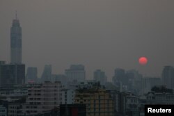 FILE - The sun is seen through evening air pollution in Bangkok, Thailand, Feb. 8, 2018.