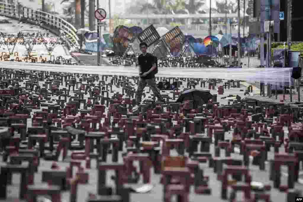 A man walks through bricks placed on a barricaded street outside The Hong Kong Polytechnic University in Hong Kong.