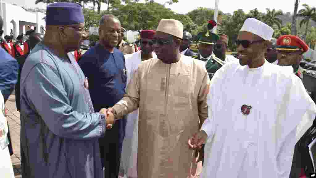Le ministre nigérian de l&#39;Intérieur, Abdulrahman Danbazau, souhaite la bienvenue au président sénégalais Macky Sall, et au président nigérian Muhammadu Buhari, juste avant une réunion à Abuja, le 9 janvier 2017.