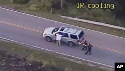 FILE - In this photo made from a Sept. 16, 2016, police video, Terence Crutcher, left, with his arms up, is pursued by police officers as he walks next to his stalled SUV moments before he was shot and killed by one of the officers in Tulsa, Okla.
