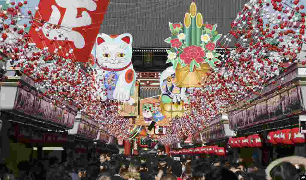 Warga berjalan di bawah dekorasi untuk menyambut Tahun Baru pada sebuah lorong dekat kuil Asakusa Sensoji, Tokyo, Jepang.