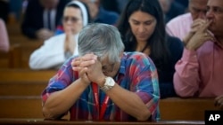 FILE - People pray as the church discuss the Supreme Court hearing arguments regarding the U.S. Constitution requiring states to allow same-sex marriages, April 29, 2015 in Miami. On Feb. 12, 2018, a gay schoolteacher has been fired by a Miami Catholic school after marrying her same-sex partner in an apparent violation of church rules, church officials said.