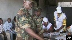 A member of Guinea's military casts a ballot during Guinea's first round of presidential elections