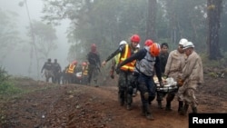 Rescatistas recuperan los cadáveres del helicóptero accidentado.