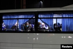 Autobuses que transportan a los pasajeros estadounidenses del crucero Diamond Princess, donde decenas de personas dieron positivo por coronavirus, salen en la Terminal de Cruceros Daikoku Pier en Yokohama, al sur de Tokio, Japón, el 17 de febrero de 2020. REUTERS / Issei Kato.