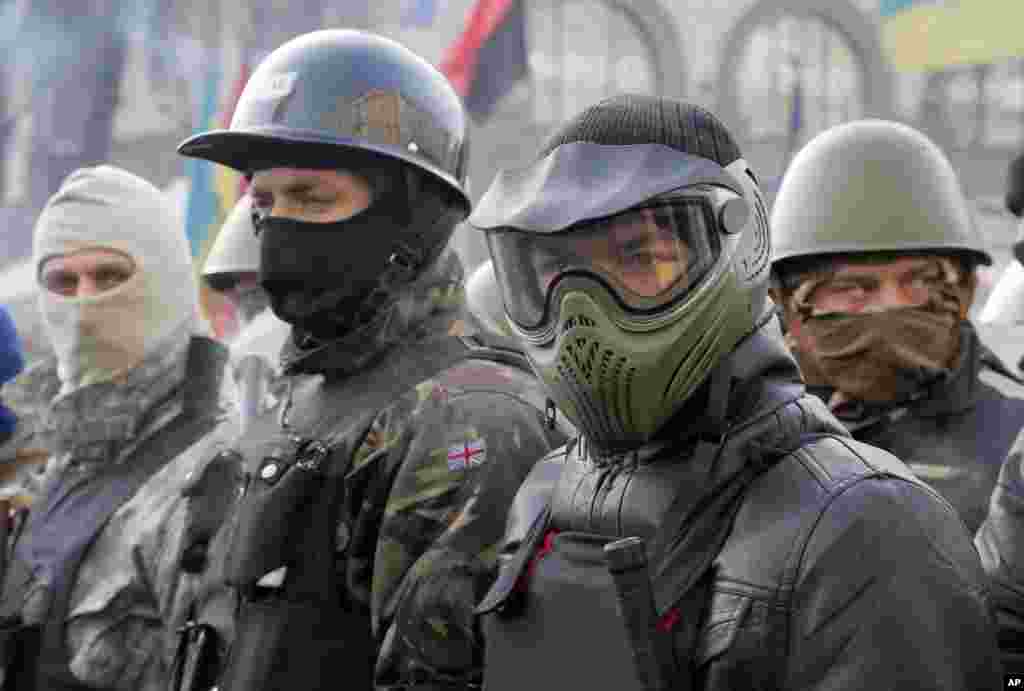 Anti-government protesters, wearing protective head gear, prepare to rally in Kyiv's Independence Square, Feb. 6, 2014.