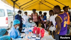 Haitian migrants gather to be tested for COVID-19 after U.S. authorities flew them out of a Texas border city, at Toussaint Louverture International Airport in Port-au-Prince, Haiti Sept. 21, 2021.