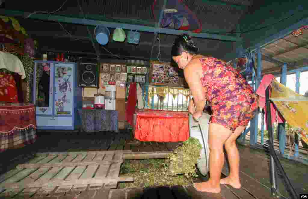 ស្រ្តីជនជាតិវៀតណាមម្នាក់ (មិនមែនមានន័យថាខុសច្បាប់ទេ) ដាក់ចំណីត្រីនៅលើផ្ទះលើទន្លេមួយ នៅសង្កាត់ព្រែកប្រា ខណ្ឌច្បារអំពៅ រាជធានីភ្នំពេញ នៅថ្ងៃសុក្រ ទី១៩ ខែសីហា ឆ្នាំ២០១៦។(ឡេង ឡែន/VOA)