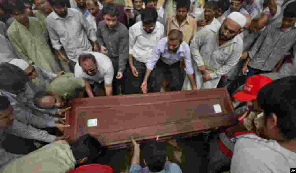 Relatives and colleague carry the casket of Pakistani journalist Saleem Shahzad for burial at a graveyard after funeral prayers in Karachi June 1, 2011. Speculation that Pakistan's military spy agency had a hand in the death of a prominent journalist has 