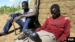 FILE - Zimbabweans listen to a radio for an announcement of election results in Umguza.