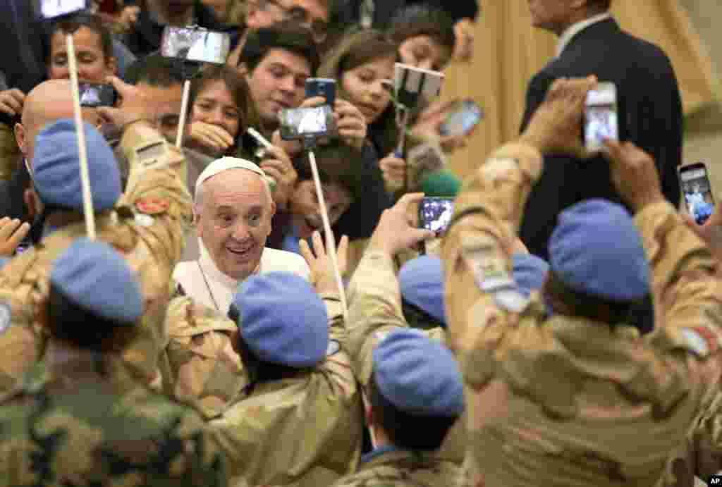 Pope Francis is greeted by Argentinian officers of the United Nations Peacekeeping Force in Cyprus, UNFICYP, as he arrives for his weekly general audience in Pope Paul II Hall, at the Vatican. &nbsp; 