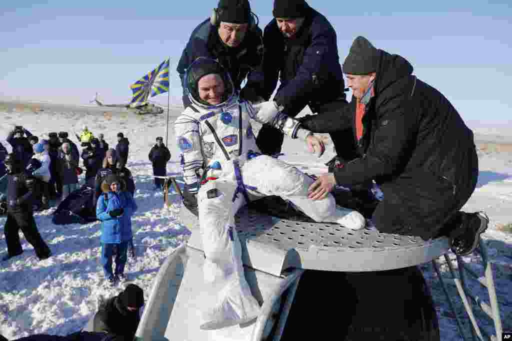 &#39;소유즈 MS-05&#39; 우주선이 카자흐스탄 남동부 카자크 마을에 무사귀환한 후 러시아 우주인 세르게이 랴잔스키 씨가 러시아 우주공사 직원들의 도움을 받아 캡슐에서 내리고 있다.