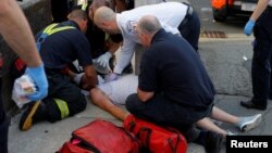 Cataldo Ambulance paramedics and firefighters treat a 32-year-old man who was found unresponsive on a sidewalk after overdosing on opioids in Everett, Mass., Aug. 23, 2017. 