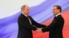 Russian President Vladimir Putin, left, and former President Dmitry Medvedev shakes hands at the inauguration ceremony. 