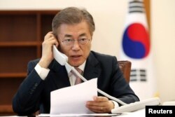 South Korean President Moon Jae-in speaks with Chinese President Xi Jinping by telephone at the Presidential Blue House in Seoul, South Korea, May 11, 2017.