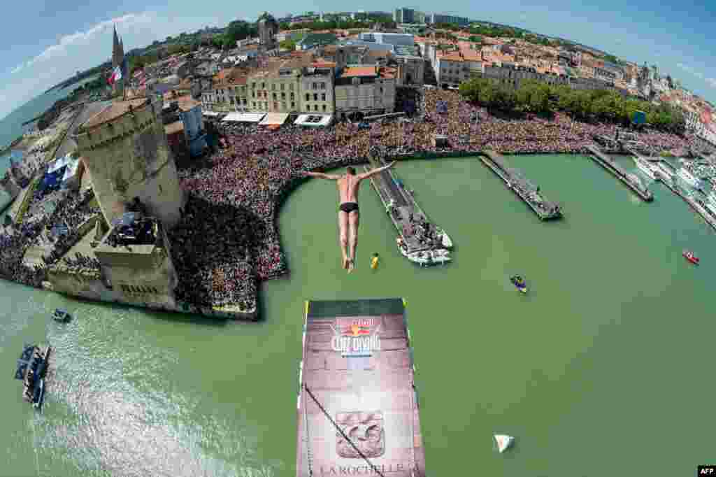 Um flyer da Red Bull mostra Artem Silchenko de Rússia a mergulhar da plataforma a uma distância de 27.5 metros, na Torre de São Nicolau durante a segunda parte do &quot;Red Bull Cliff Diving&quot; campeonato em La Rochelle, França