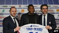 Karl Toko Ekambi, au centre, pose avec son nouveau maillot à Lyon, France, le 21 janivier 2020.
