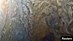 Gambar yang didistribusikan NASA dengan warna yang diperjelas menunjukkan titik gelap yang misterius di permukaan Jupiter menunjukkan pusaran topan mirip “galaksi” di planet raksasa diambil dari wahana angkasa milik NASA, Juno, pada tanggal 2 Februari 2017 pada ketinggian 14.500 kilometer di atas permukaan awan Jupiter (foto: atas perkenan NASA/Roman Tkachenko/JPL-Caltech/Didistribusikan via Reuters)