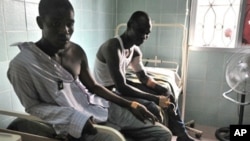 Wounded men receive medical care at a hospital in Abidjan's Treichville neighborhood on March 8, 2011