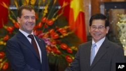 Visiting Russian president Dimitry Medvedev (L) shakes and with his Vietnamese counterpart Nguyen Minh Triet during an official welcoming ceremonyat the presidential palace in Hanoi, 31 Oct 2010