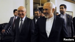 Sartaj Aziz, left, adviser to Pakistan's prime minister on foreign affairs, escorts Iranian Foreign Minister Javad Zarif to their meeting at the Foreign Ministry in Islamabad, April 8, 2015. 