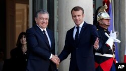 French President Emmanuel Macron, right, shakes hands with Uzbek President Shavkat Mirziyoyev, prior to their meeting at the Elysee Palace, in Paris, France, Oct. 9, 2018.