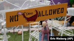 Dino, the pet dinosaur, stands in a carriage in the front yard of the Flintstone House in Hillsborough, Calif.