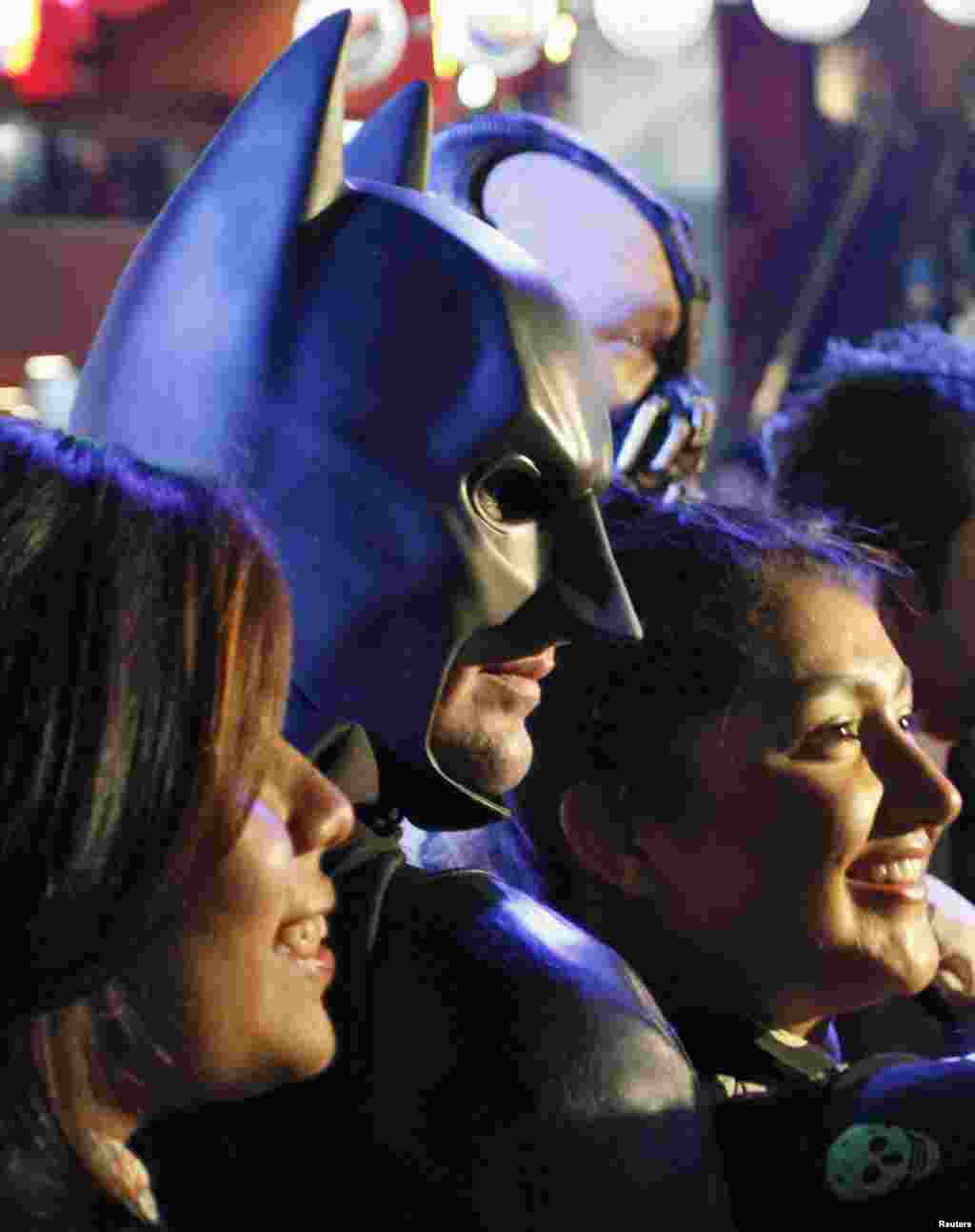 Un hombre vestido de Batman posa con los fan&aacute;ticos del personaje.