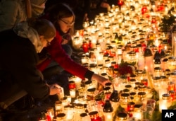 FILE - Candles are placed outside the French embassy in Vilnius, Lithuania, for the victims in Friday's attacks in Paris, Nov. 14, 2015.